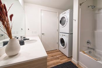 A kitchen with a washing machine and a sink and a washer and dryer